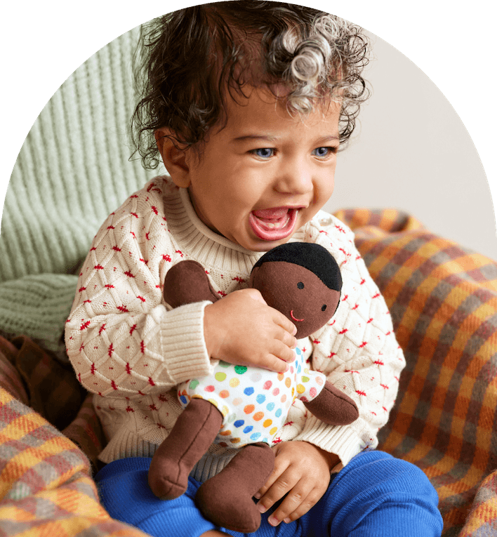 Child holding the Organic Cotton Baby Doll from Lovevery